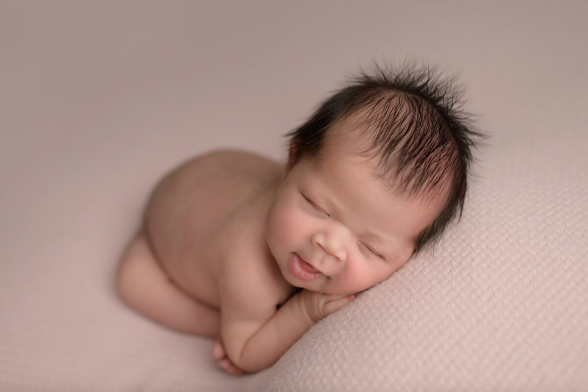 Sleeping newborn baby girl with smile