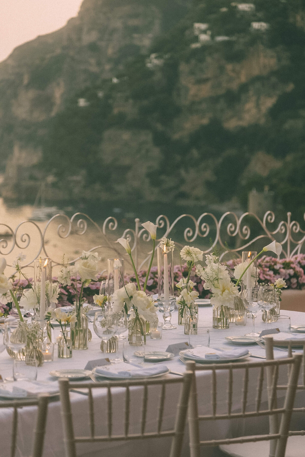 Table set up with wedding flowers by Europe-wide photographer at Italian coastal ceremony