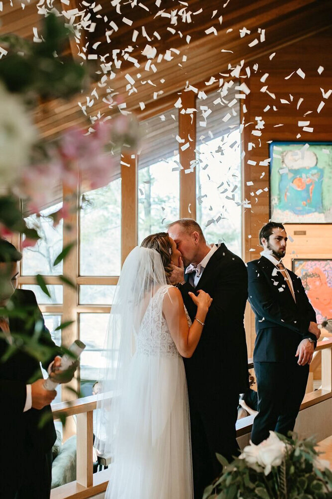 storyteller-collective-photo-co-chapel-wedding-kiss-confetti-des-moines-iowa