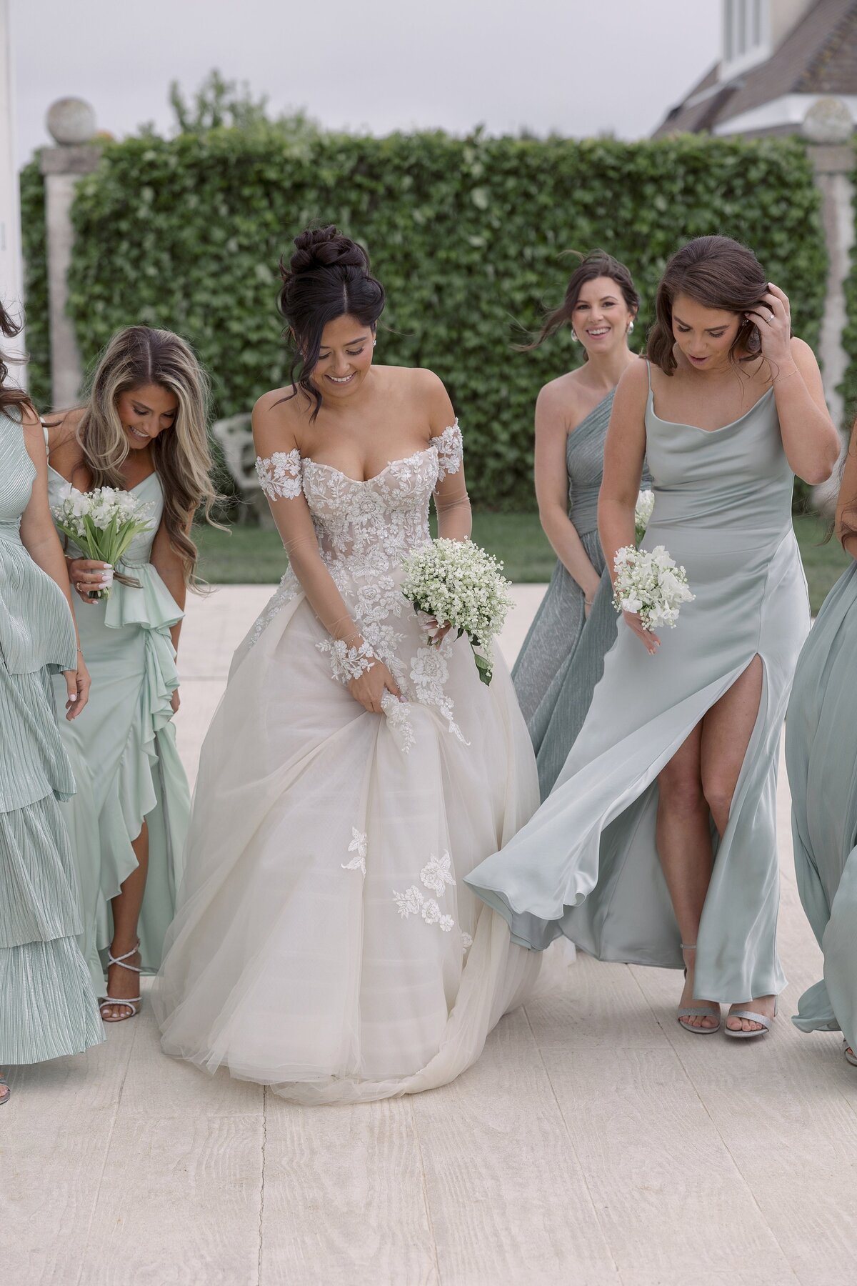 Bride walks with bridesmaids on ground of Belle Mer Newport Rhode Island.