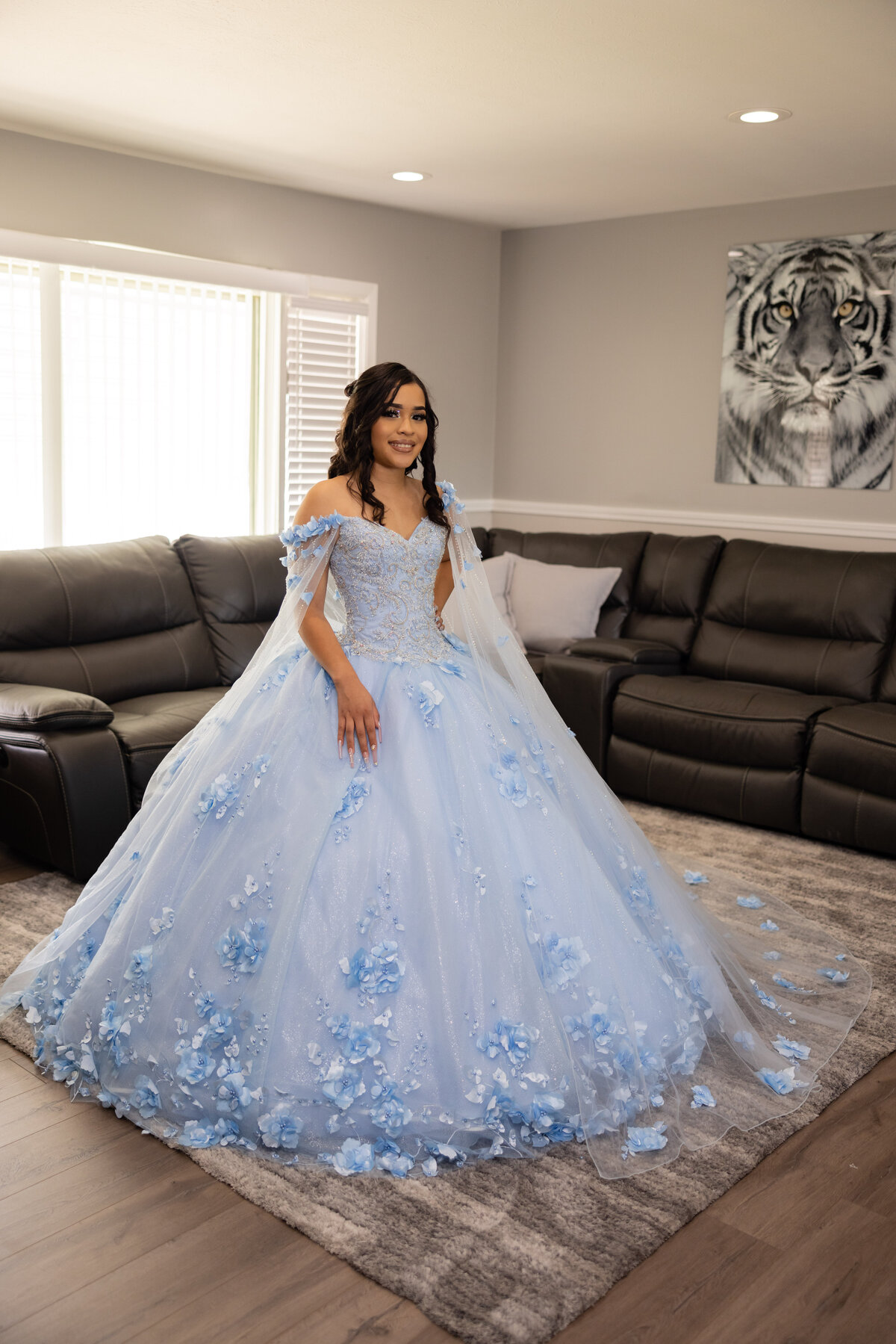 A graceful portrait of Victoria in her stunning blue quinceañera gown, captured at her home in Cleveland, Ohio, before the ceremony. TheWiz Photography highlights the anticipation of this special day.