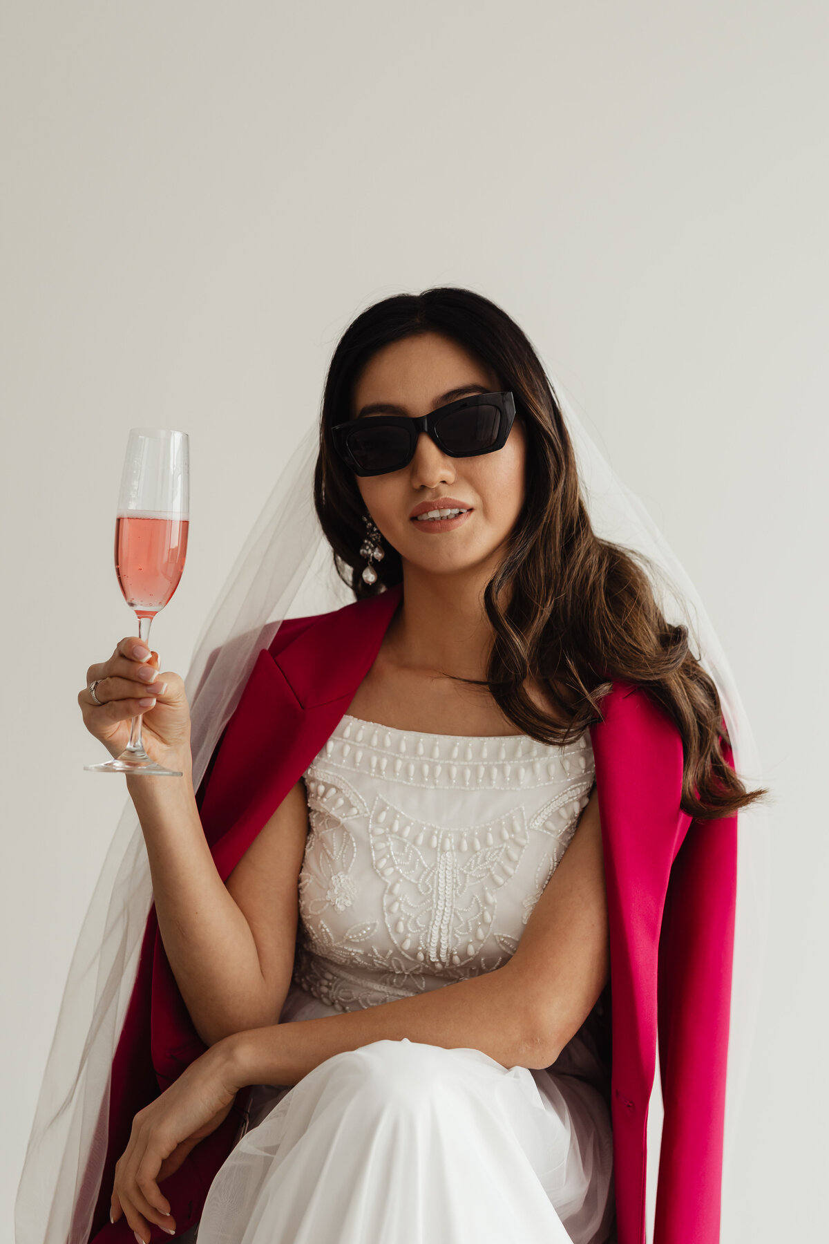 kaboompics_wedding-bride-portrait-veil-glass-of-champagne-sunglasses-pink-jacket-29773