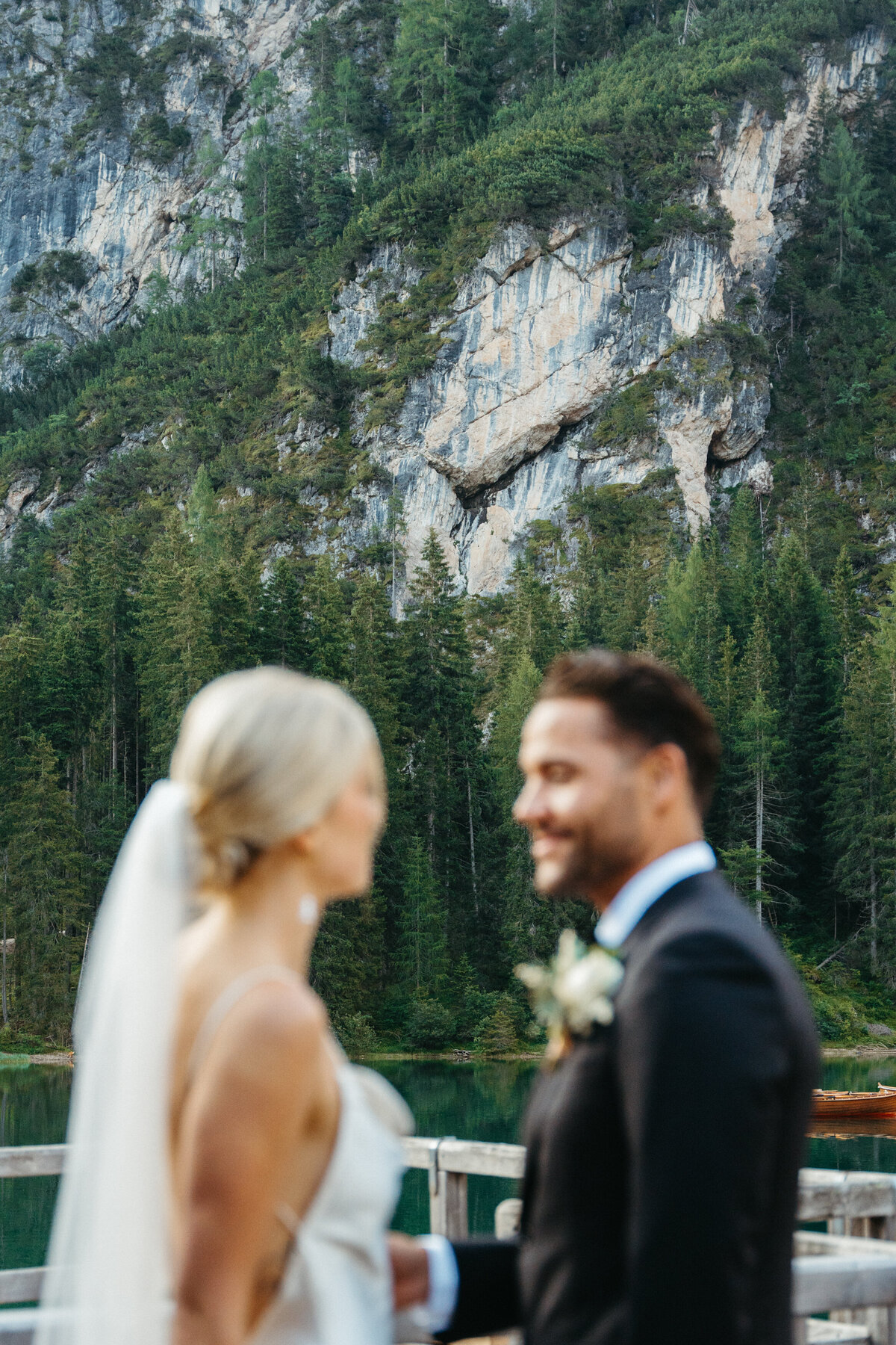 Bride and groom smiling together with Dolomites cliffs in background