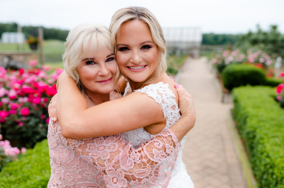 bride and mother of the bride hugging at the outdoor wedding venue in little rock