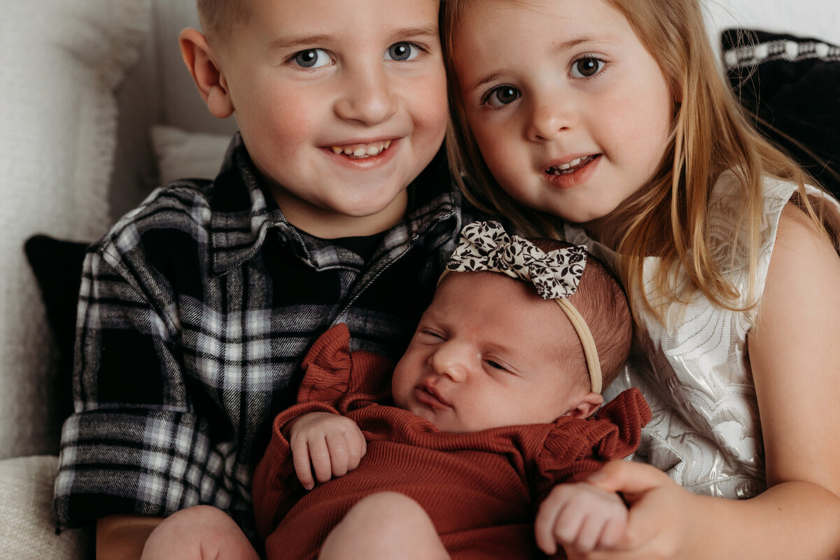 lubbock newborn photographer captures a beautiful portrait of three little ones smiling at the camera