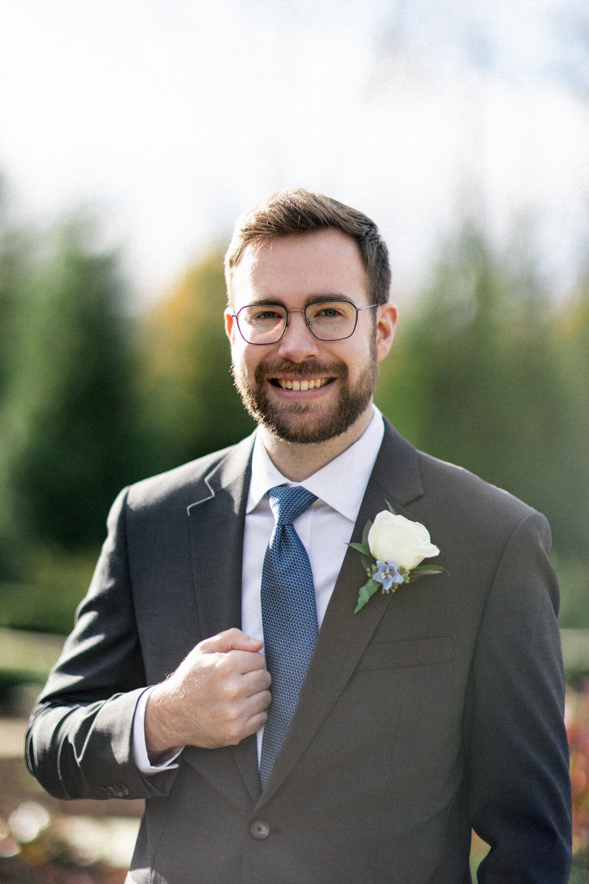 Groom smiling in suit with blue tie at late fall wedding in Cleveland.
