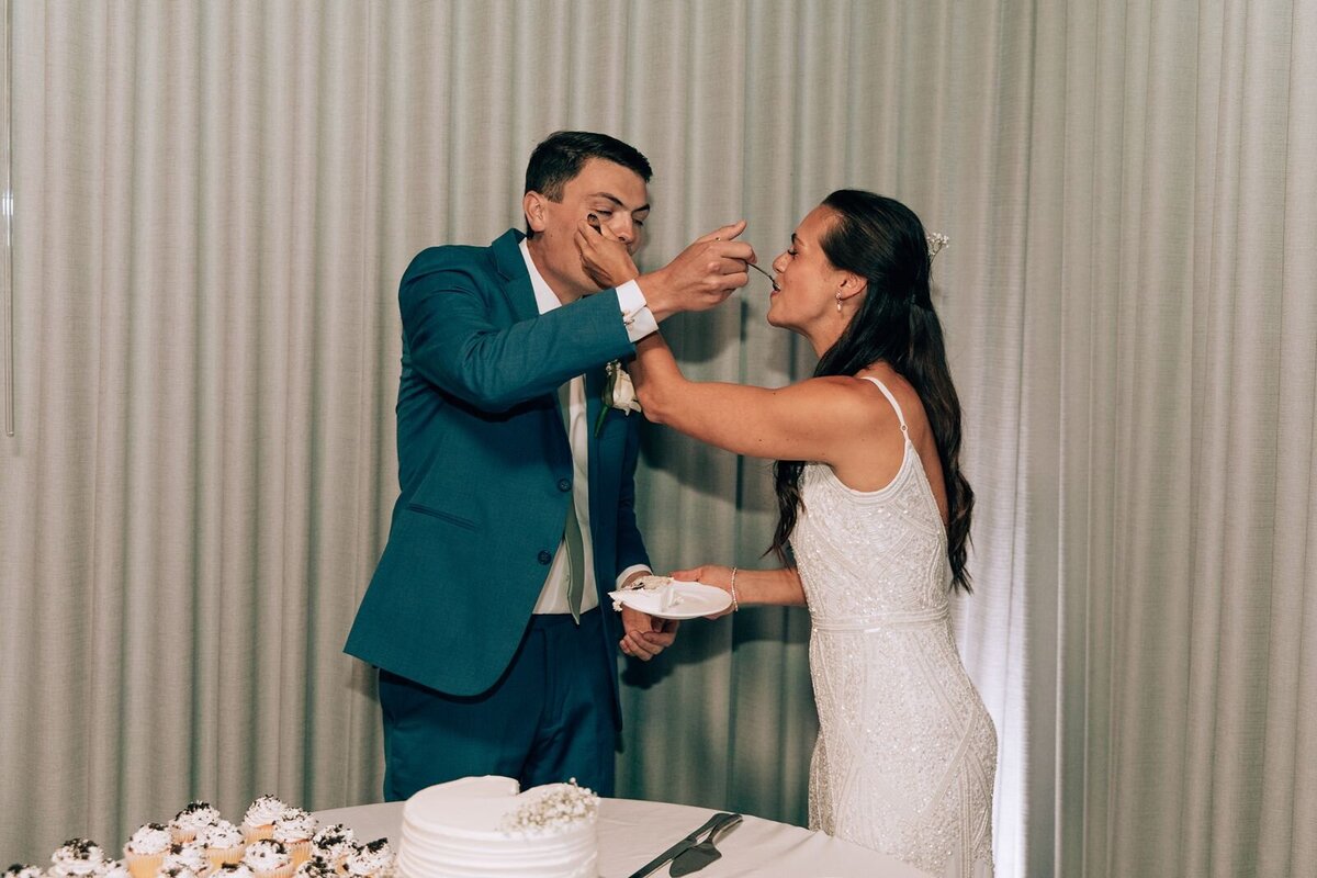 bride and groom feeding eachother their wedding cake