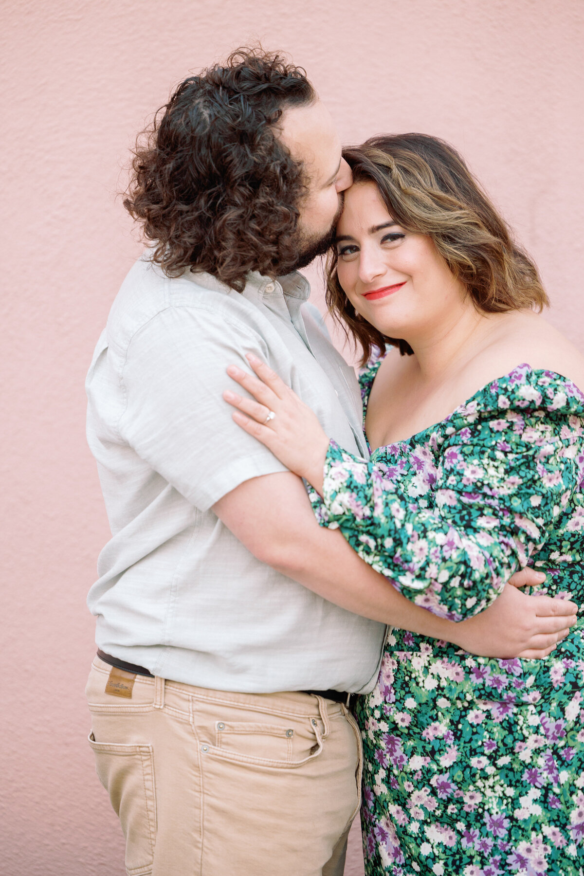 A person kissing their partner's forehead