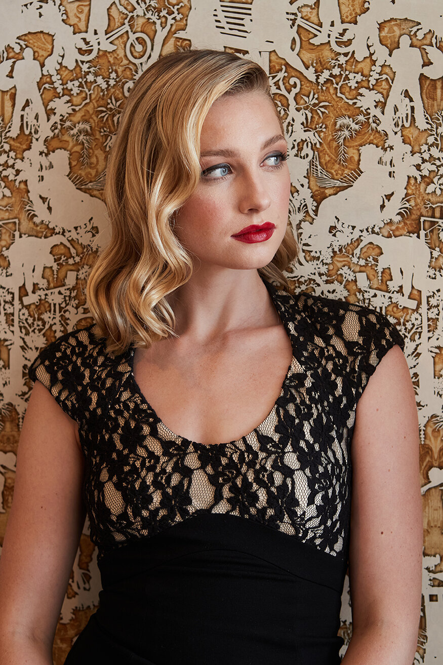 Elegant portrait of Ellie Bisping wearing a sparkling top, with a composed expression, shot by Ylva Erevall.