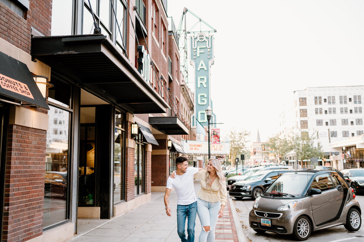 engaged couple walking in a downtown area