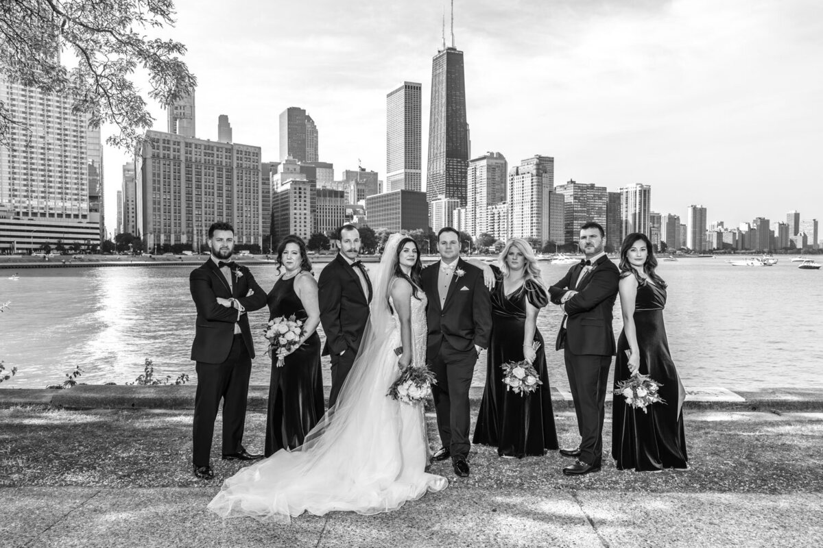 A black and white photo of a bride and groom and their wedding party