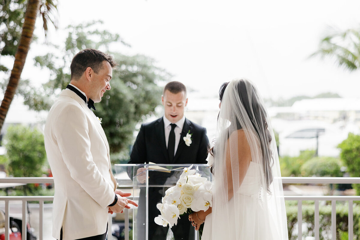The bride and groom exchanging heartfelt glances during their ceremony at Ocean Reef in Key Largo, beautifully captured by Claudia Amalia Photography at Ashley and Cameron's micro wedding.
