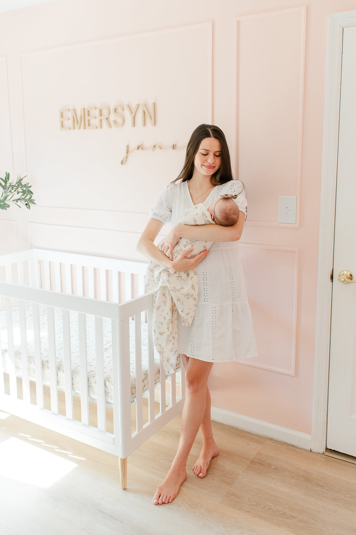 Orlando newborn photographer captures new mom holding her baby in her room during newborn photos