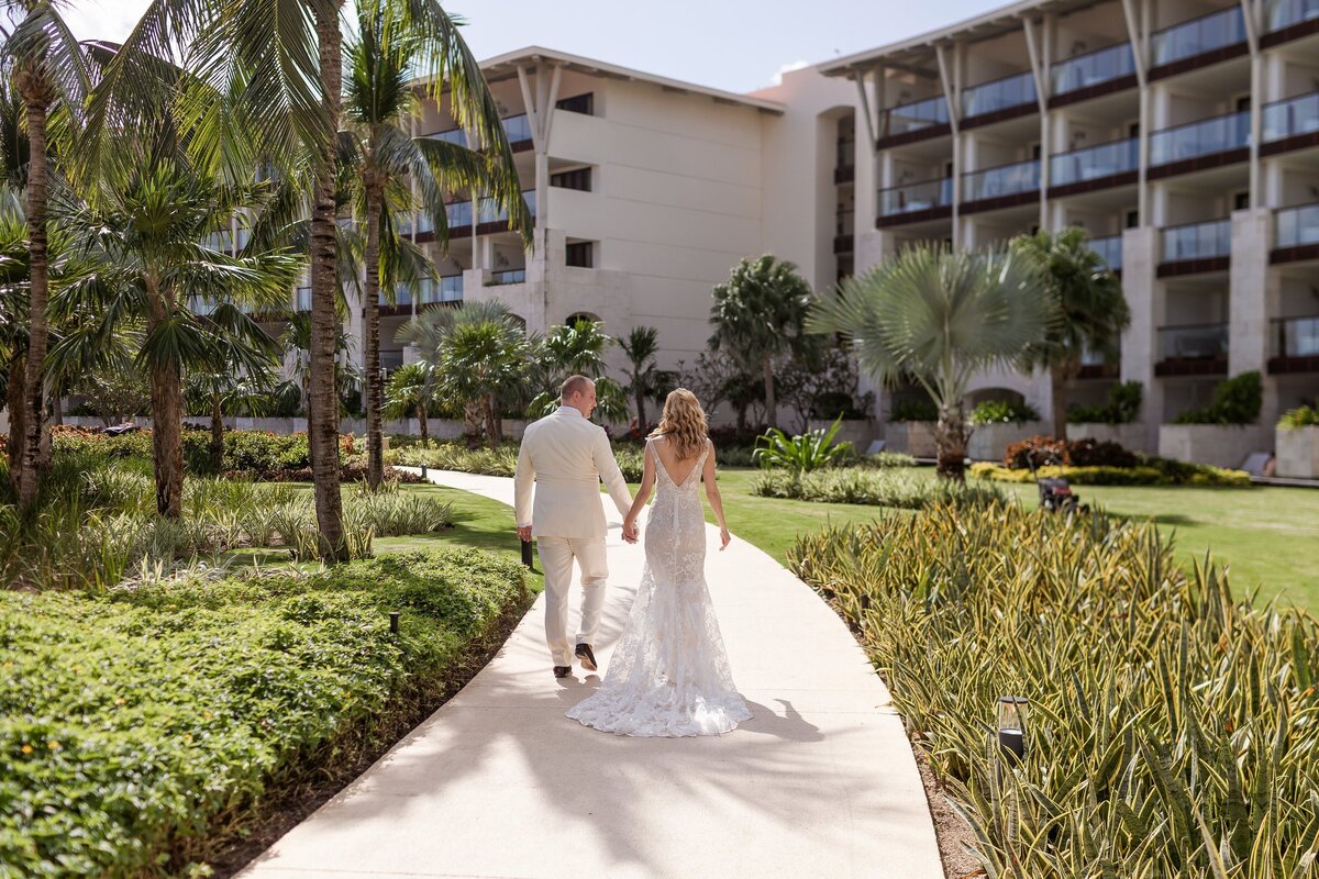 Bride and groom walking on path at wedding in Riviera Maya