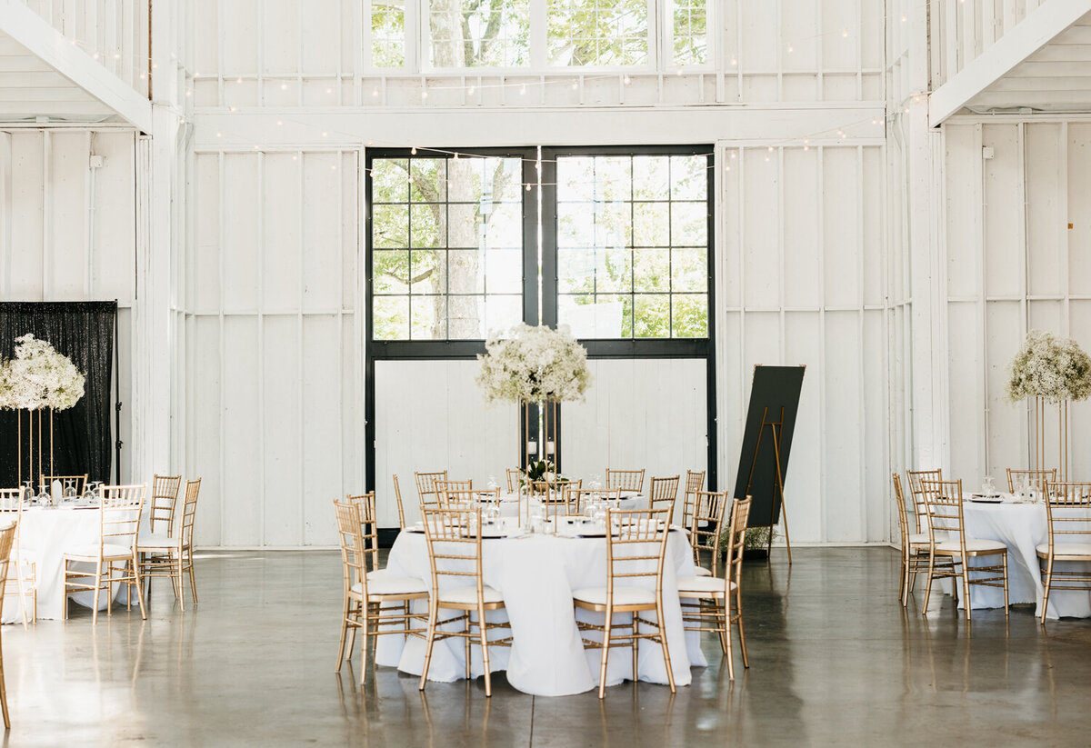 Elegant reception setup at Ashford Acres Inn, Cynthiana, KY featuring ornate table settings, luxurious gold accents, and classic white floral arrangements, creating a timeless and opulent atmosphere for a memorable wedding celebration.
