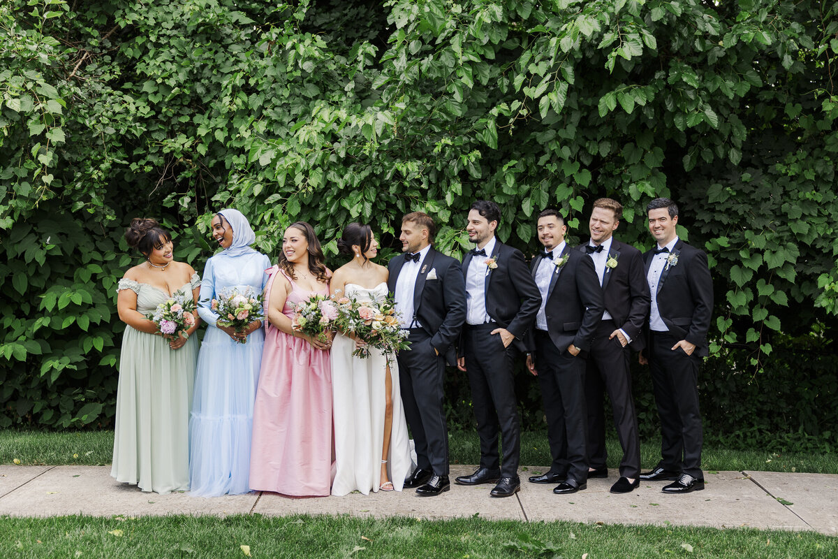 Summer wedding party photo in front of greenery at The Roundhouse