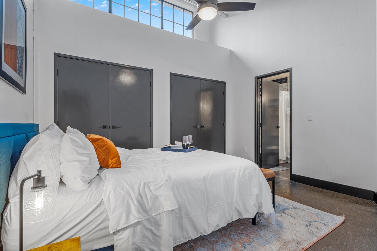 Bedroom with plenty of natural light in this one-bedroom, one-bathroom loft vacation rental condo with high speed WiFi, fully stocked kitchen, and room for four guests in downtown Waco, TX.