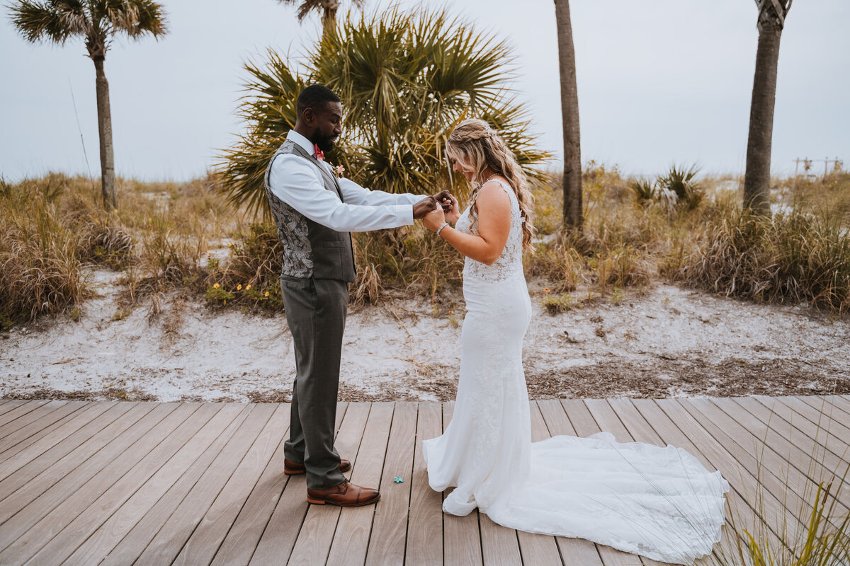 bride and groom checking eachother out for first look on the beach