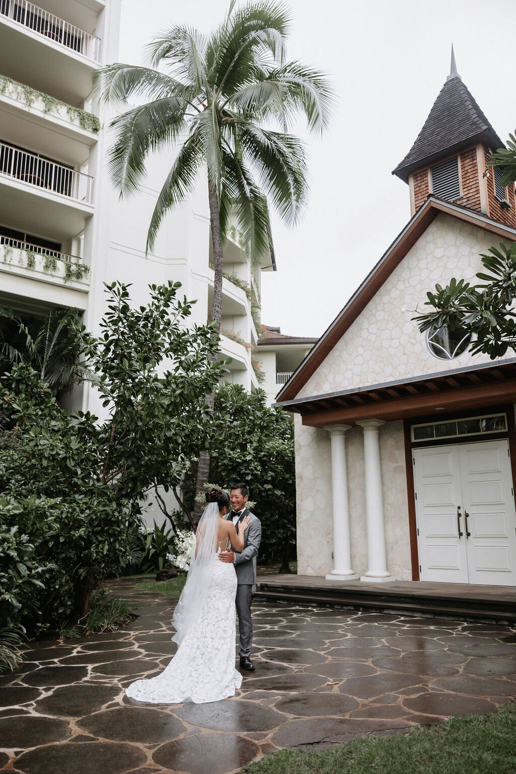 Bride and groom kissing at four seasons in front of tiny chapel four seasons oahu