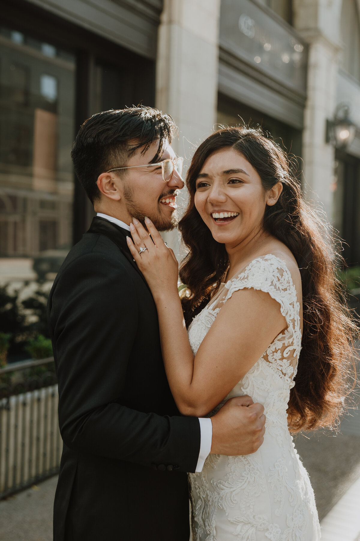bride laughing while groom hugs her