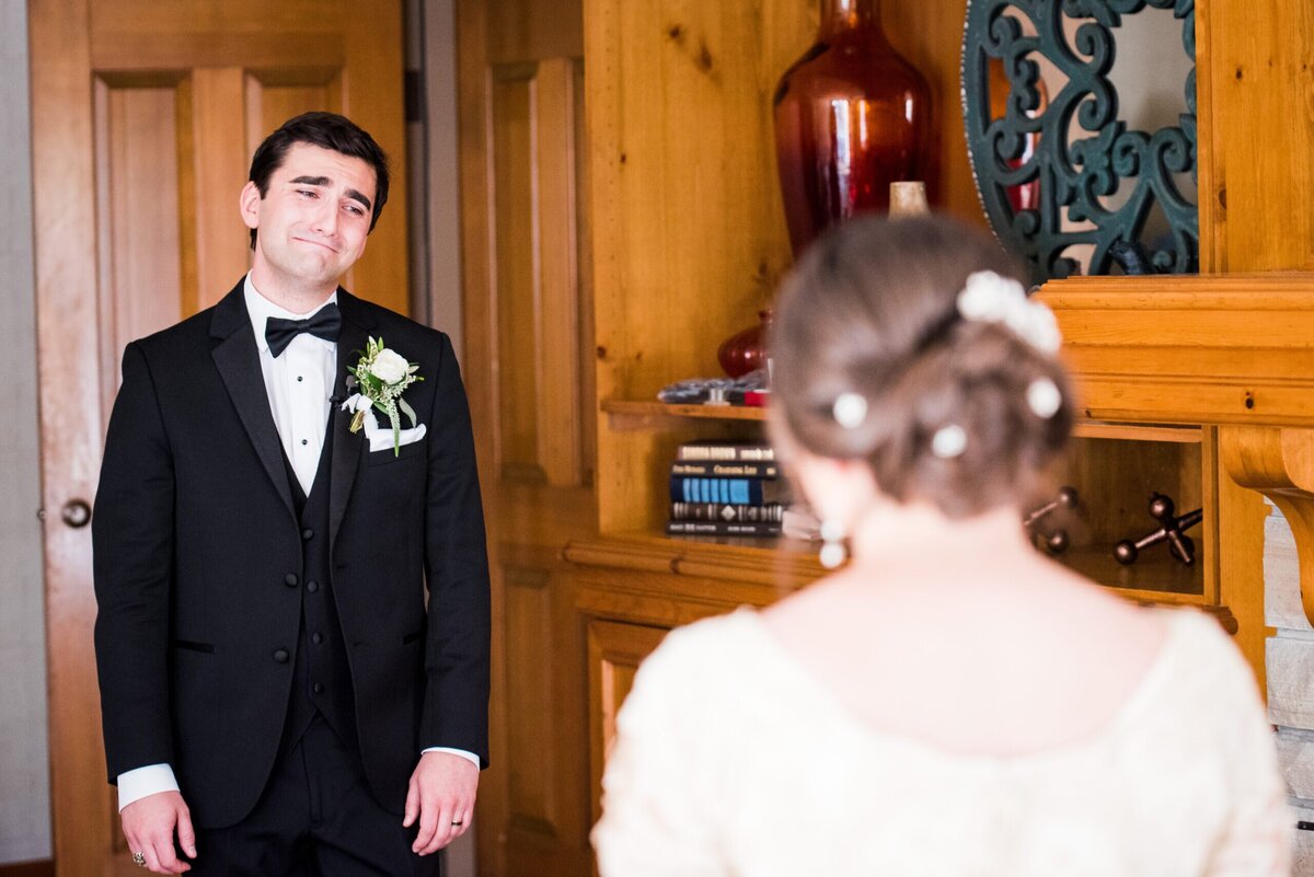 A groom reacts emotionally during a first look with his bride on their wedding day.