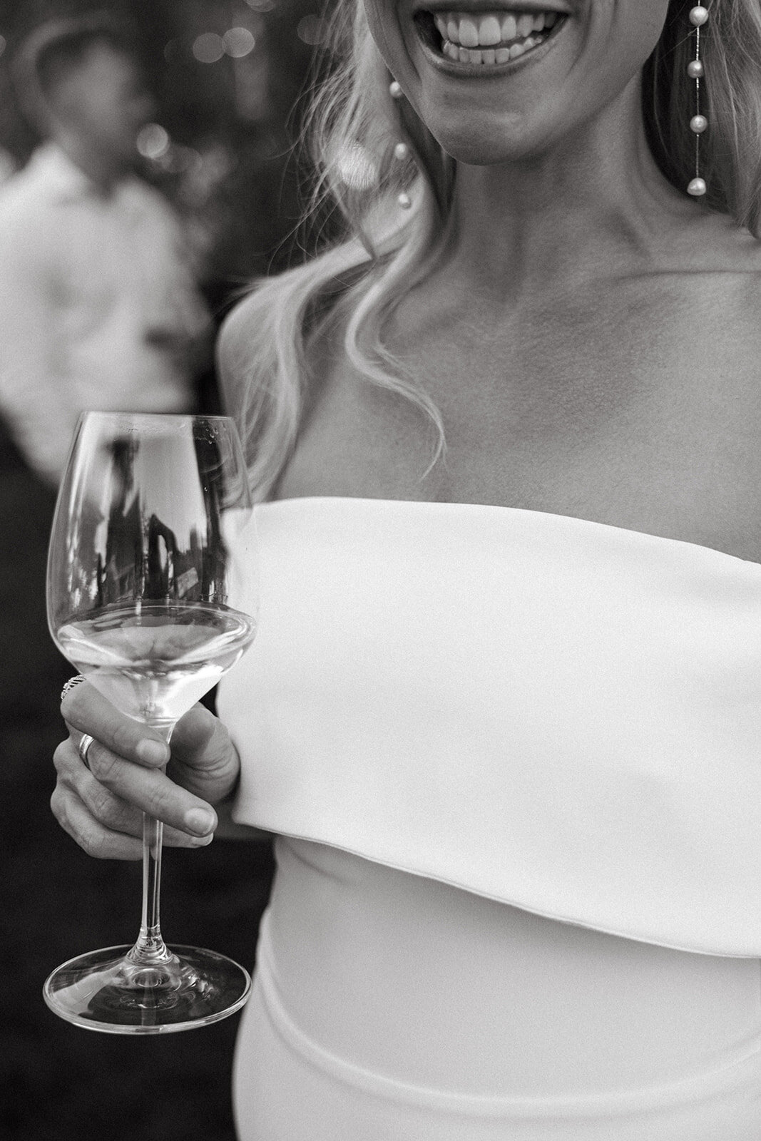 bride holding wine glass smiling with focus on glass