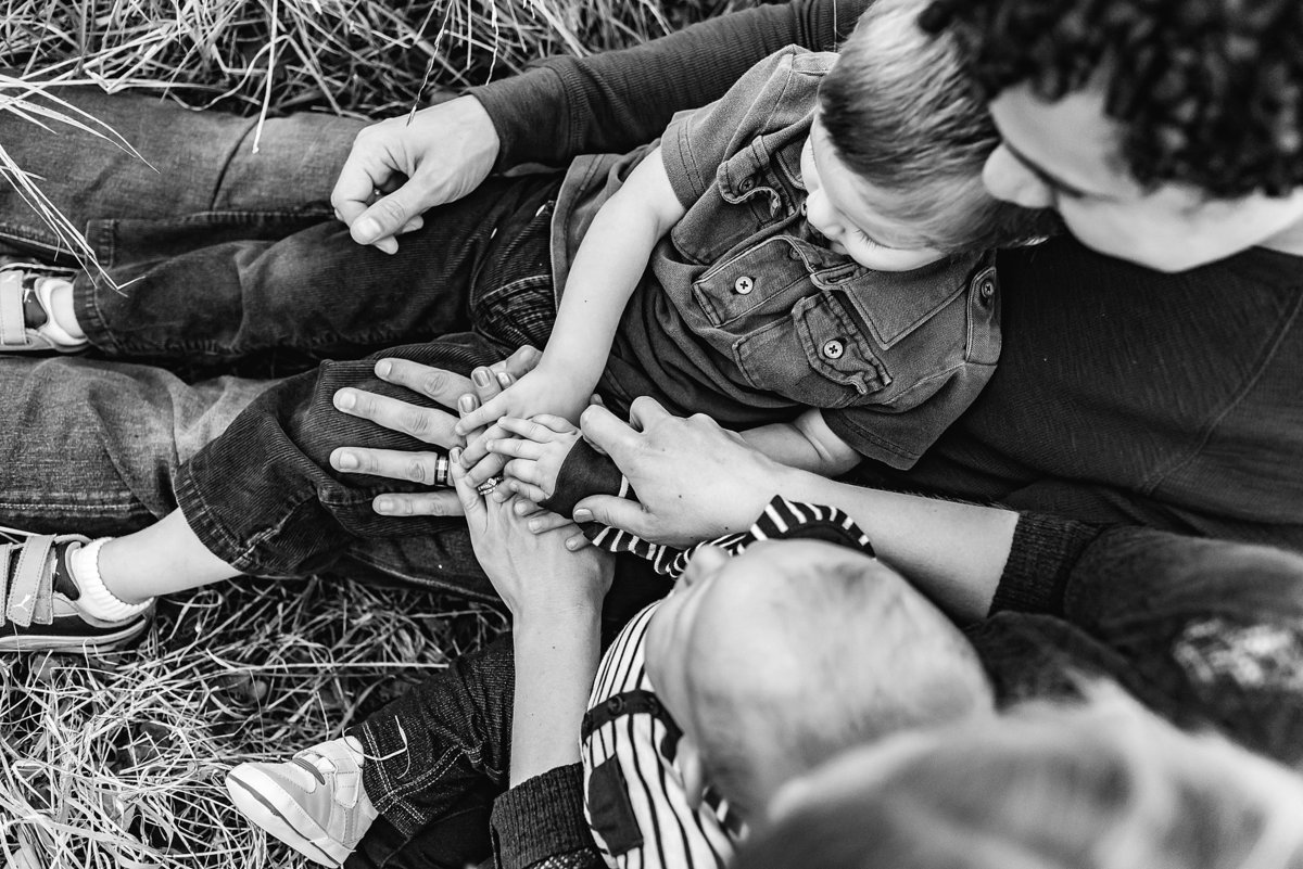 Family putting hands together black and white