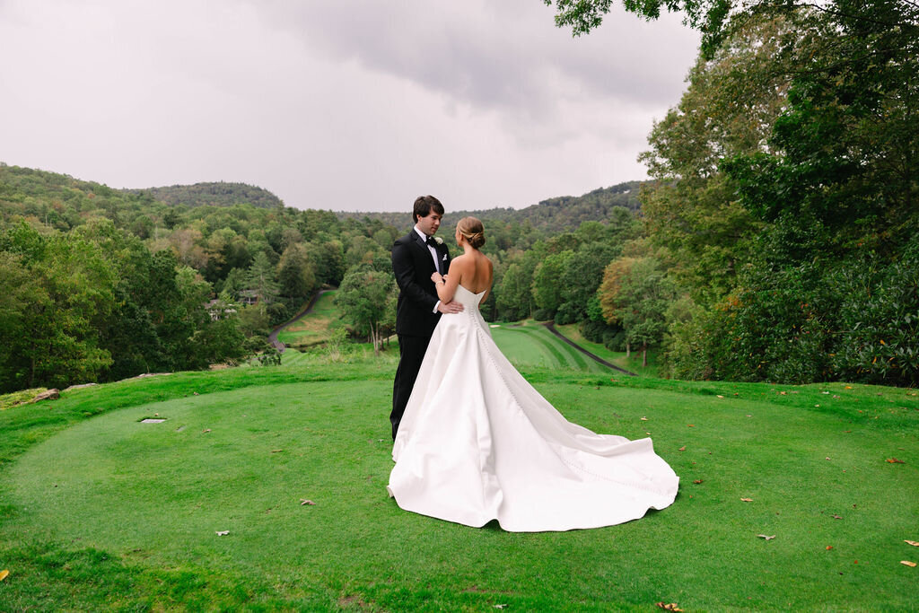 Bride and groom sharing a quiet moment on a mountain golf course in Highlands, NC during their wedding day.