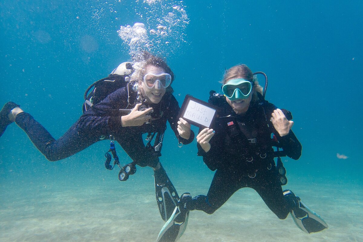 A same sex lesbian couple  scuba dives on their Hawaii adventure elopement