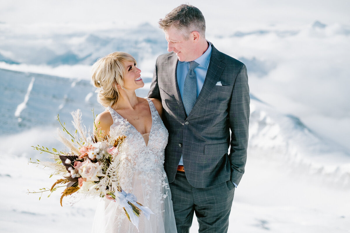 Bride and groom in the mountains with florals by Lovella Lifestyle, whimsical and romantic Edmonton wedding florist, featured on the Brontë Bride Vendor Guide.
