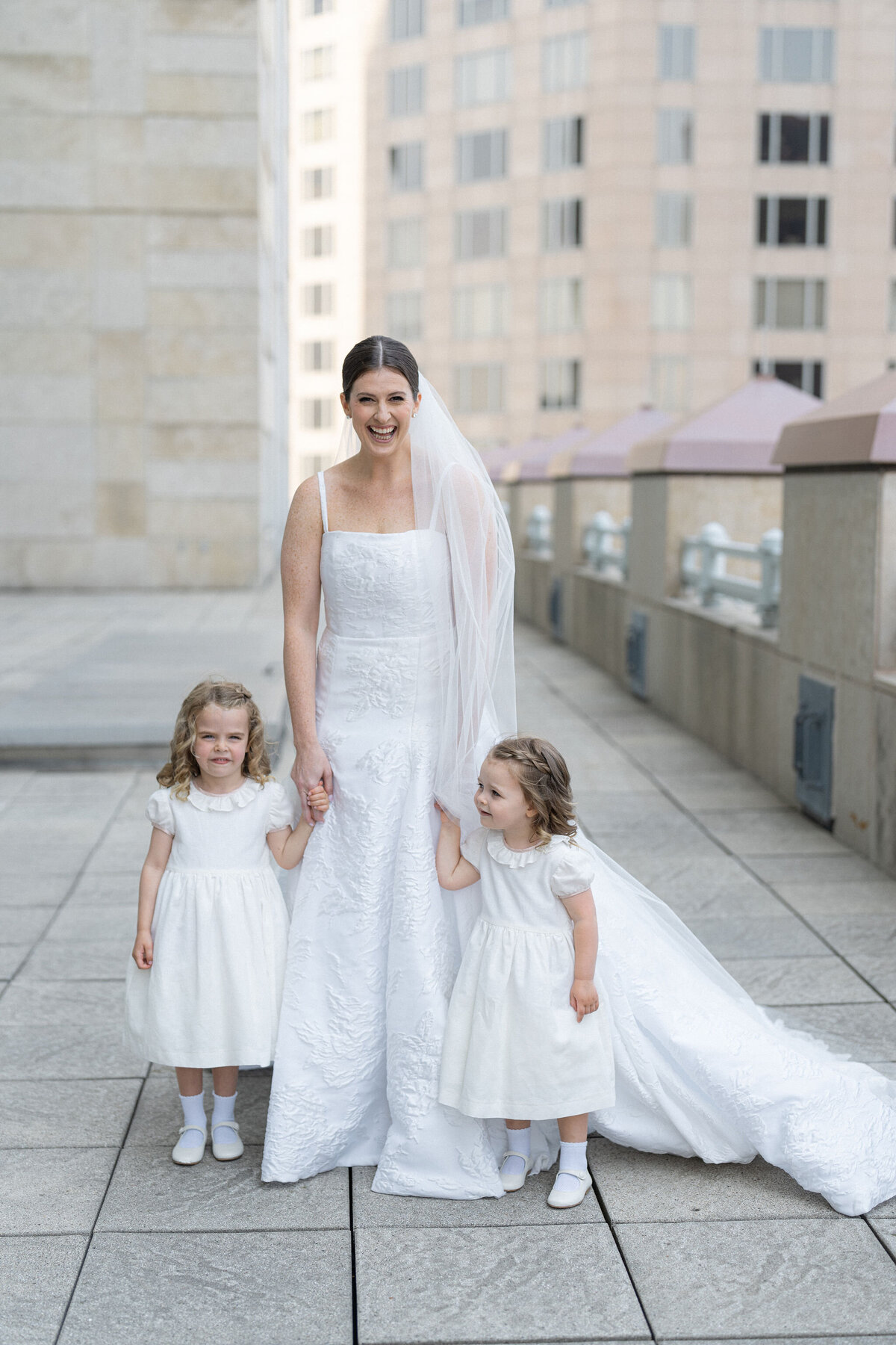 Bride with two young flower girls in white dresses at Saddle Country Club.