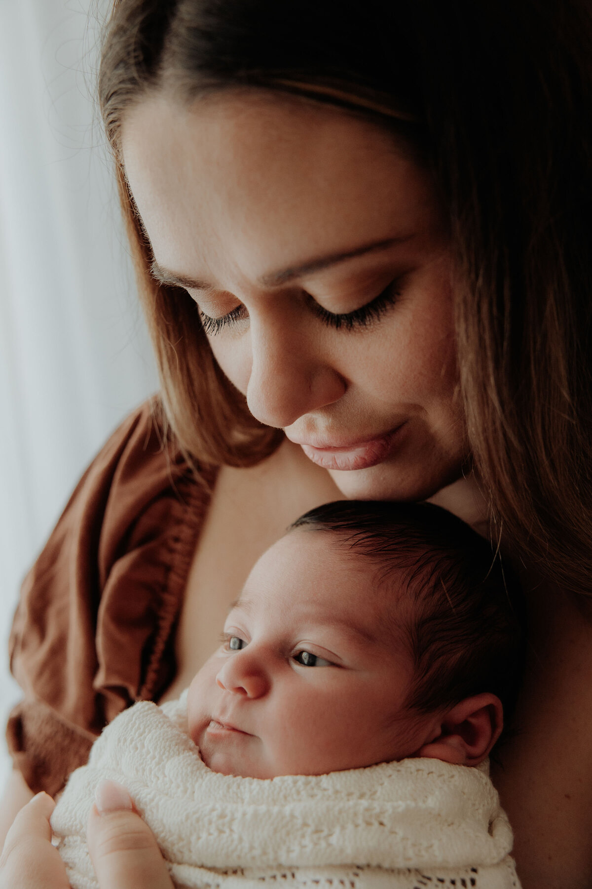 Close up side view of mum holding newborn baby