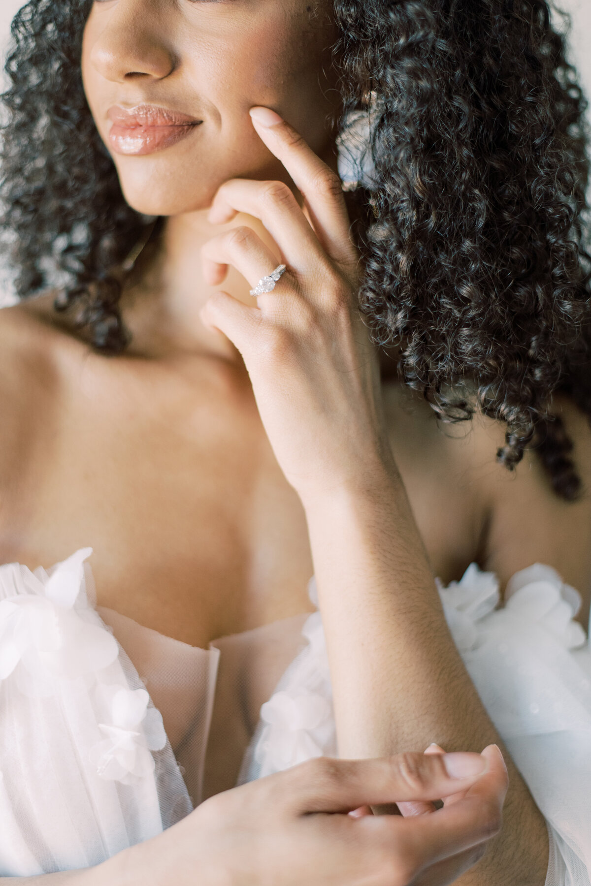 A bride’s hand gently touching her cheek, adorned with a sparkling engagement ring, captured by Christine Grace Photography in Toronto.
