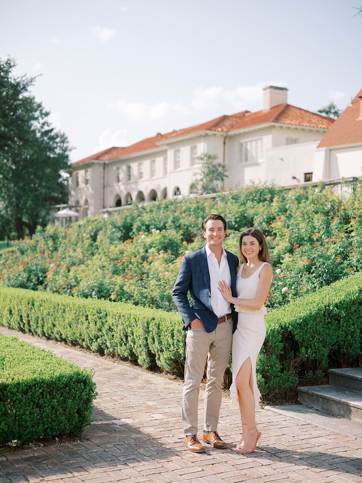 A newly engaged couple poses for a photo in The Commodore Perry Estate's gardens