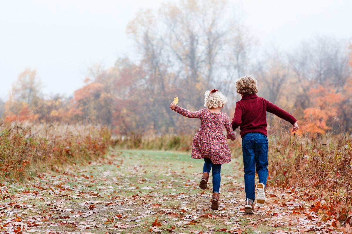 kids skipping off into a field of tall grass