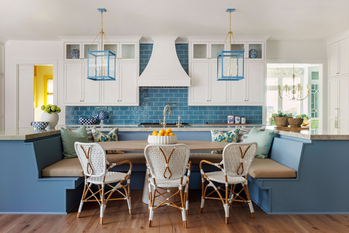 oyster creek studios lighthouse on the lake blue bench with white whicker chairs in kitchen with turquoise tile and white cabinets