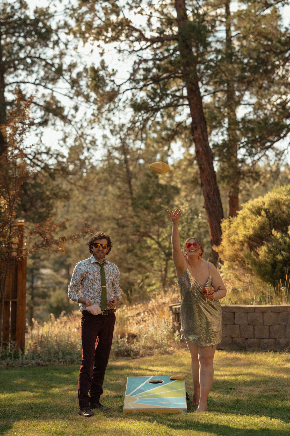 man and woman play corn hole game at a small intimate elopement celebration in Bend, OR