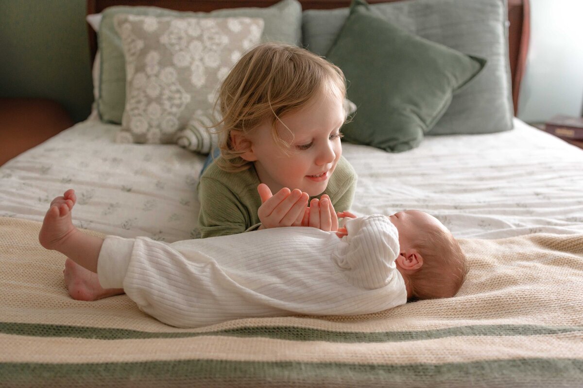 Big brother looking at his baby brother sweetly during a lifestyle newborn session in Savannah, GA