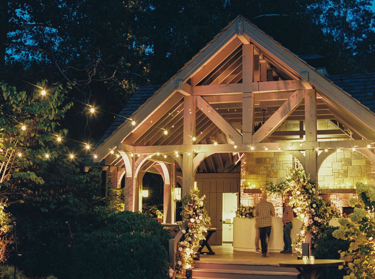 Fall wedding at Blackberry Farm. Welcome party for wedding guests at Yallerhammer Pavilion on property at Blackberry Farm. Growing floral installation with whimsical florals for entrance to reception. Rustic and earthy floral design with elegant notes of blush and cream. Wildflower design in ikebana style with glowing candlelight reception tables. Destination wedding at Blackberry Farm. Design by Rosemary & Finch Floral Design in Nashville, TN.