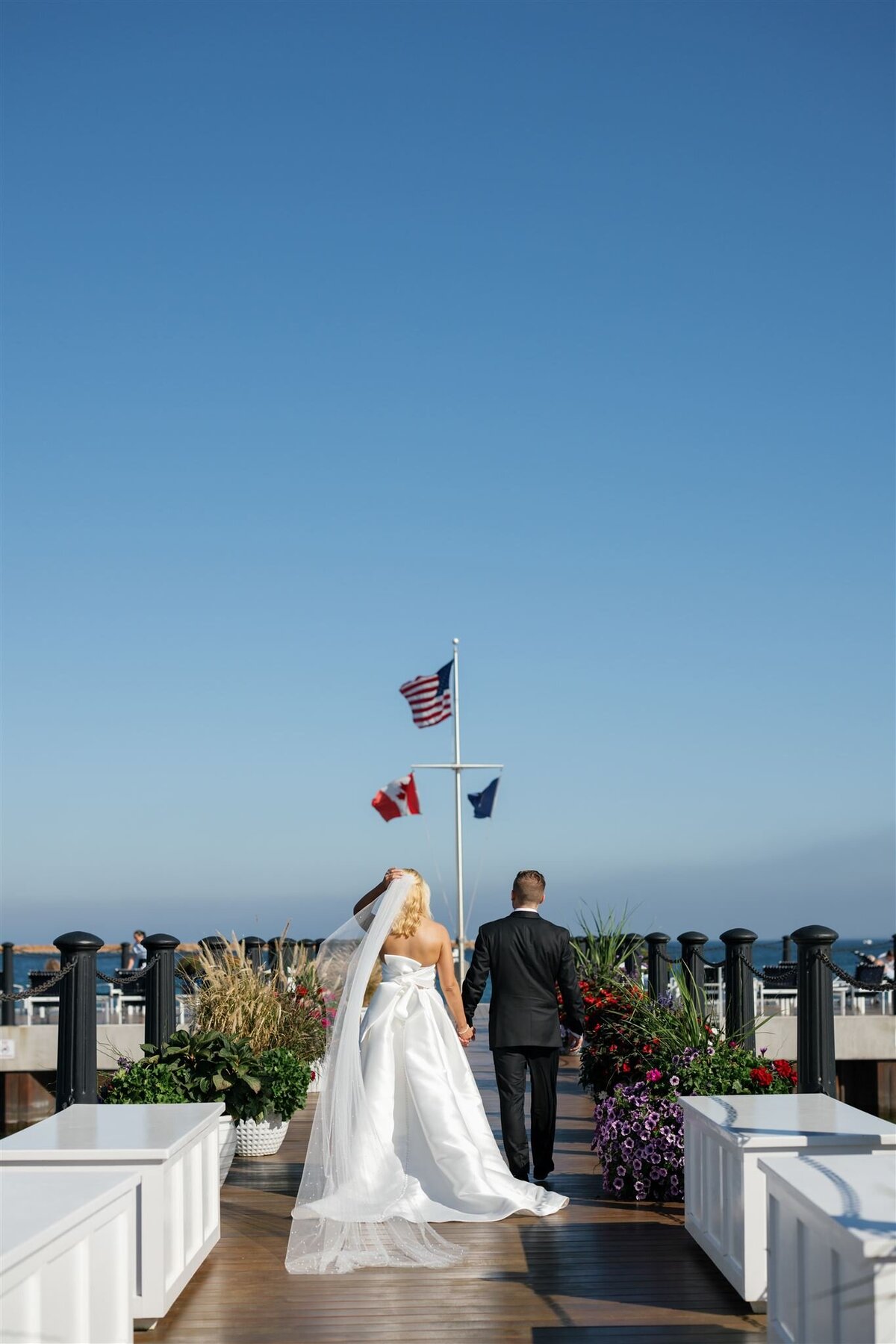 Bride and Groom looking out at the water on the dock at the Iroquois Hotel on Mackinac Island on their wedding day
