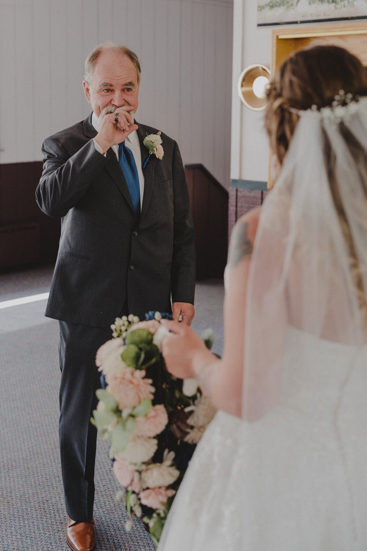 A father sees his daughter as a bride for the first time before her wedding