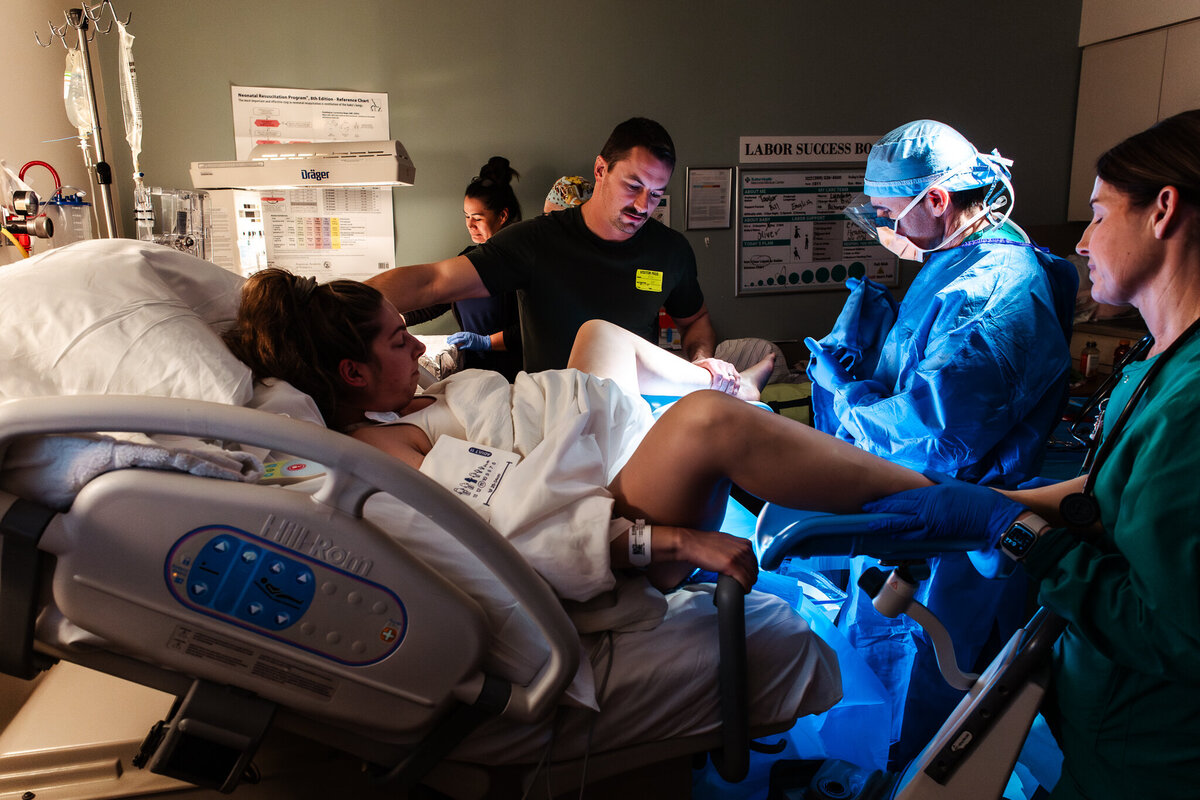  A mother has her foot in stirrups as she pushes her baby out.  Shayna Cox, a Modesto Doula, helped her to prepare for this labor. 