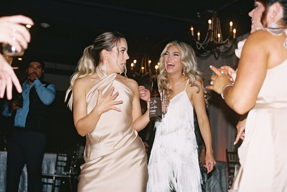 Bride and bridesmaids joyfully dancing together during the wedding celebration, captured on film by Morgan Alysse, Louisiana film photographer.