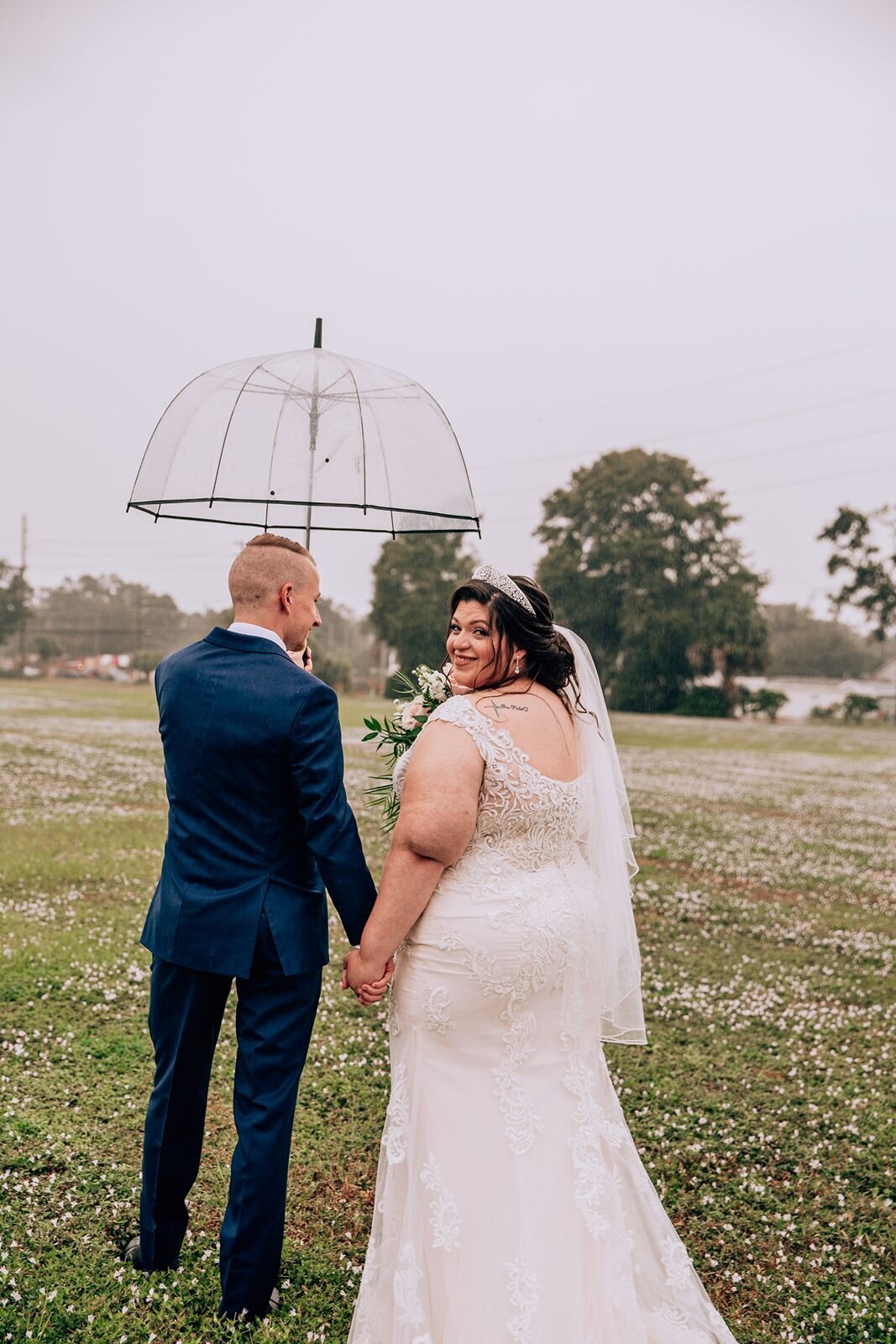 bride and groom walking in the rain with their umbrella