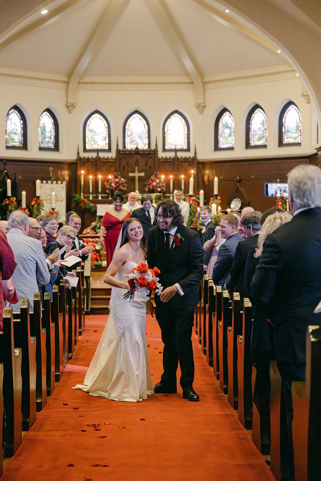 Just married couple exiting cathedral with smiling friends and family in downtown San Antonio