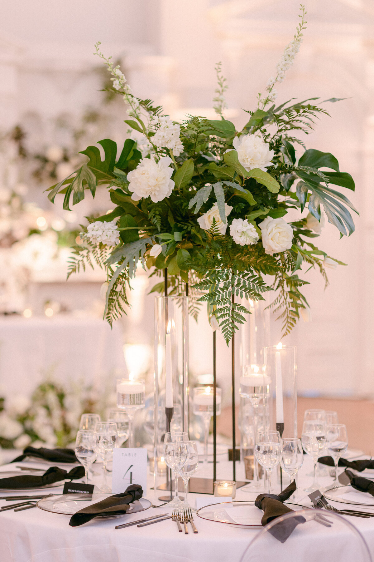 An exotic, elevated lush centrepiece on a table with candles at Maison Principale.