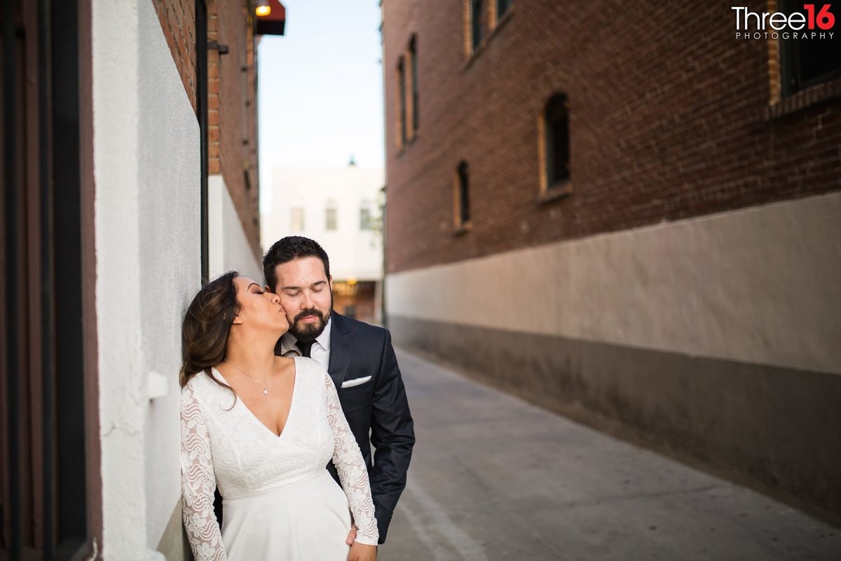 Bride to be looks back and kisses her Groom's cheek