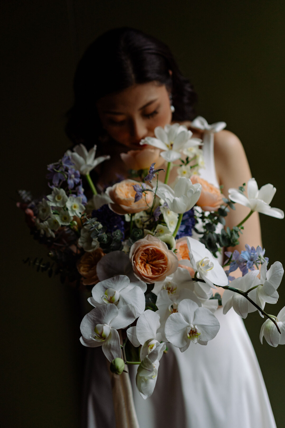 Destination wedding in Queenstown bride holds white peach and blue bouquet