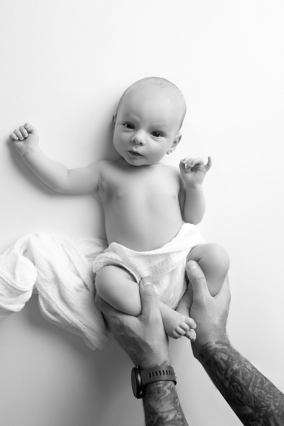 Parent hands holding newborn baby Lakeway professional family photographer