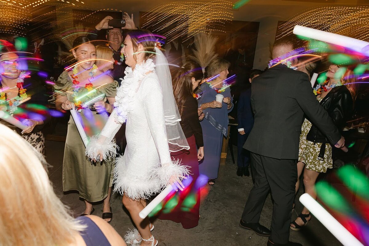 Bride dances the night away during her wedding reception with a live band and glow foam sticks at North Star Gatherings.